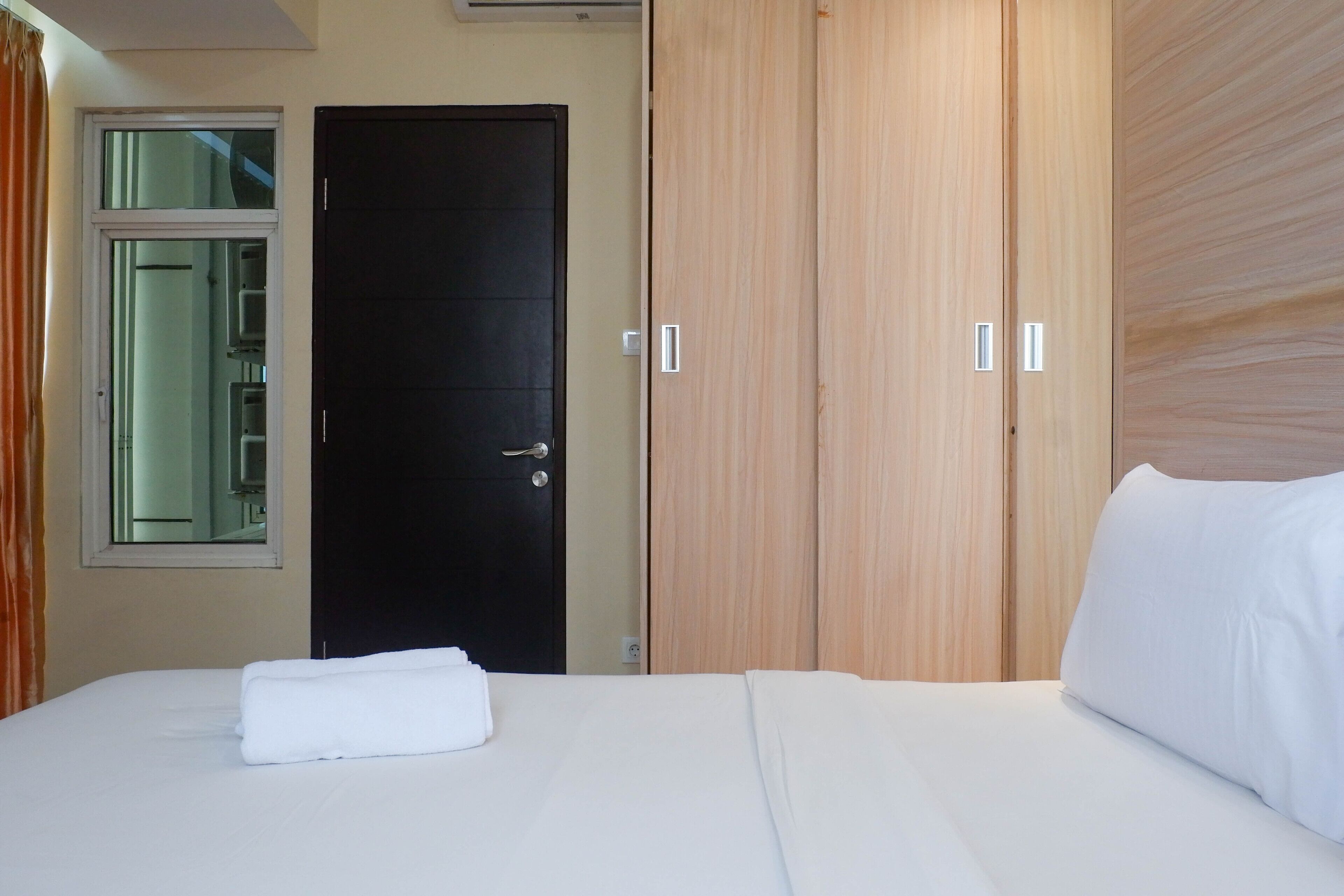 Een hotelkamer met een bed, een kledingkast en een deur.