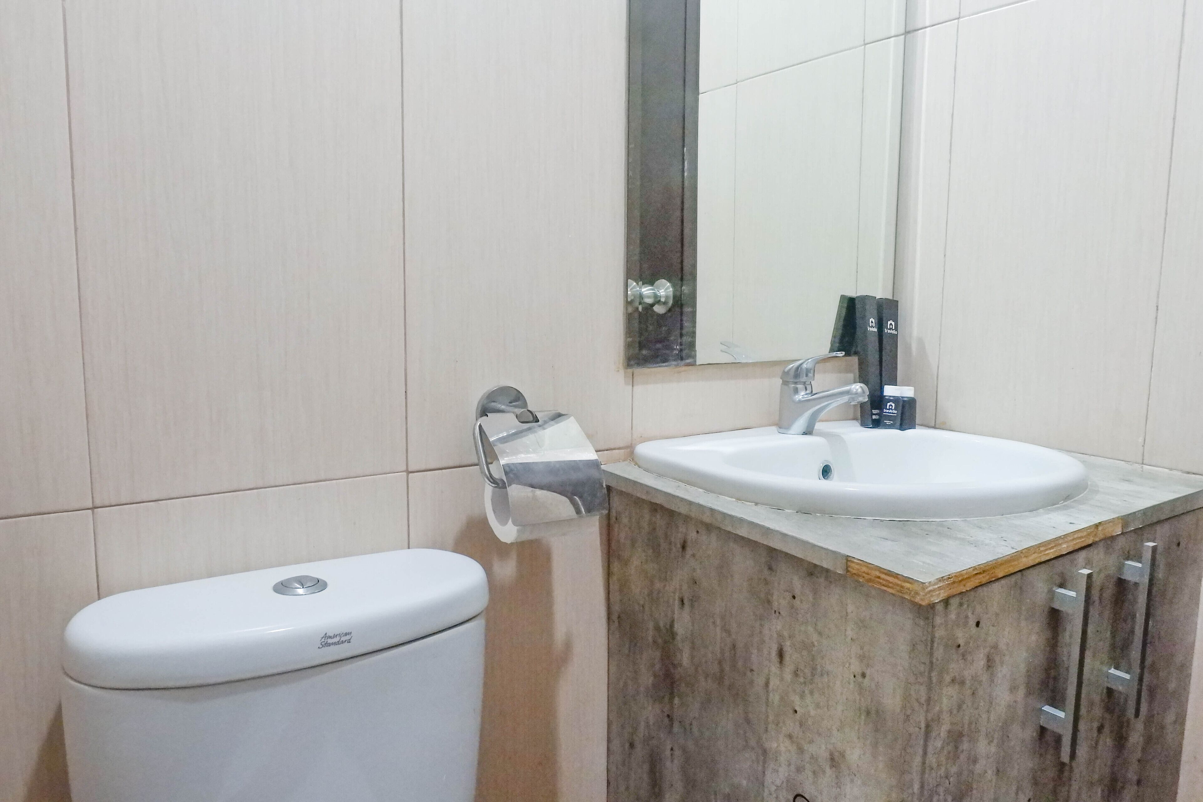 Une salle de bain avec des toilettes, un lavabo et un miroir.
