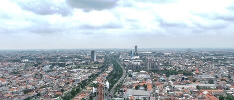 A cityscape with a prominent road running through the center, surrounded by residential and commercial buildings.