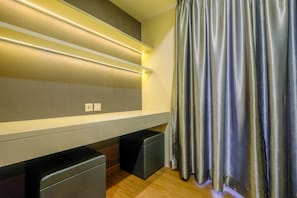 Relax in a stylish space with a comfortable sofa, bench, and elegant curtain.
