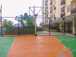 An outdoor basketball court with a basketball hoop, surrounded by a chain-link fence. - Best and Simply Homey Studio Cinere Resort Apartment (Depok)