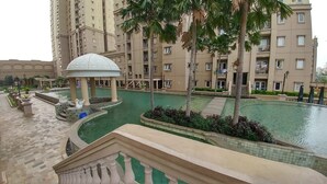 A hotel courtyard with a swimming pool, palm trees, and a gazebo. - Comfort and Stylish 2BR at Grand Palace Kemayoran Apartment (Jakarta)
