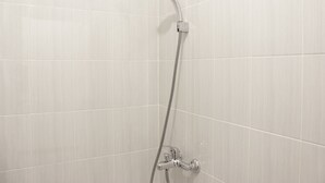 A shower with a handheld showerhead and a flexible hose.
