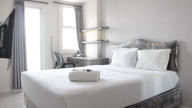 Een moderne hotelkamer met een groot bed, een bureau en een stoel.