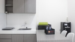Een moderne keuken met een grijze werkblad, een spoelbak en een reisstation met een waterfles en een groene dienblad.