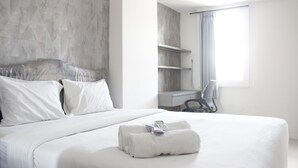 Een moderne hotelkamer met een groot bed, een bureau en een douche.