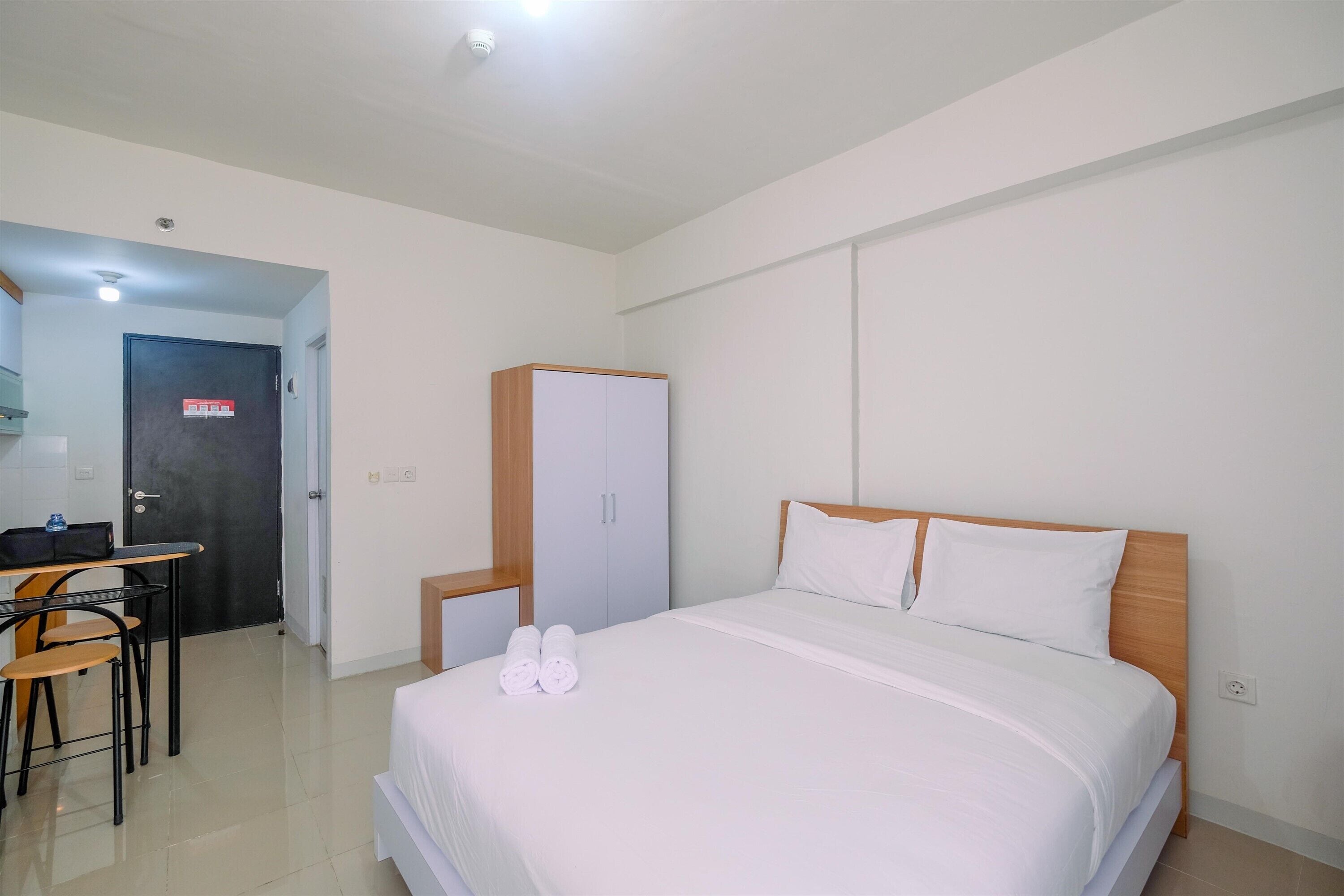 Una habitación de hotel con cama, escritorio y armario.