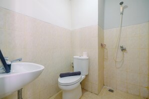 A bathroom with a toilet, sink, and shower.