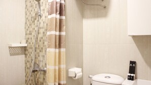 A bathroom with a shower, toilet, and a towel rack. - Luxurious Studio Room @ Grand Asia Afrika Apartment (Bandung)