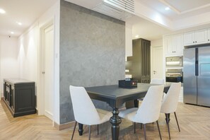 A modern kitchen with a dining table, chairs, and built-in appliances.