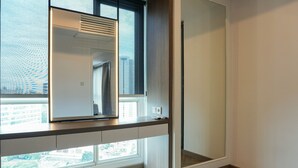 A modern room with a large window, a built-in desk, and a sliding door. - Luxurious 2BR Apartment at Casa Grande Residence (Jakarta)
