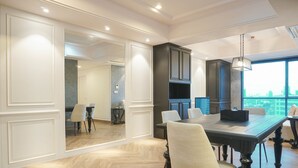 A modern dining area with a large table, chairs, and built-in cabinets. - Luxurious 2BR Apartment at Casa Grande Residence (Jakarta)