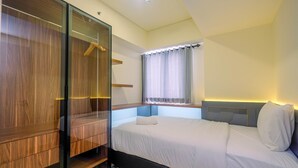 Un dormitorio con cama, armario, ventana con cortinas y mesita de noche.