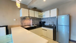 A modern kitchen with a central island, stainless steel appliances, and patterned backsplash.
