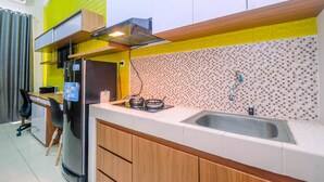Una cocina moderna con salpicadero amarillo, un lavamanos de acero inoxidable y una estufa empotrada.