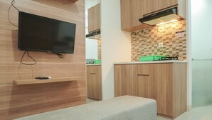 Une cuisine moderne avec des meubles en bois, un téléviseur encastré et un banc.