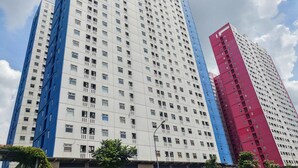 Un immeuble de grande hauteur, composé de plusieurs étages, dont les façades présentent un mélange de couleurs blanche et bleue.