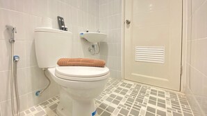 A bathroom with a toilet, a sink, and a shower.