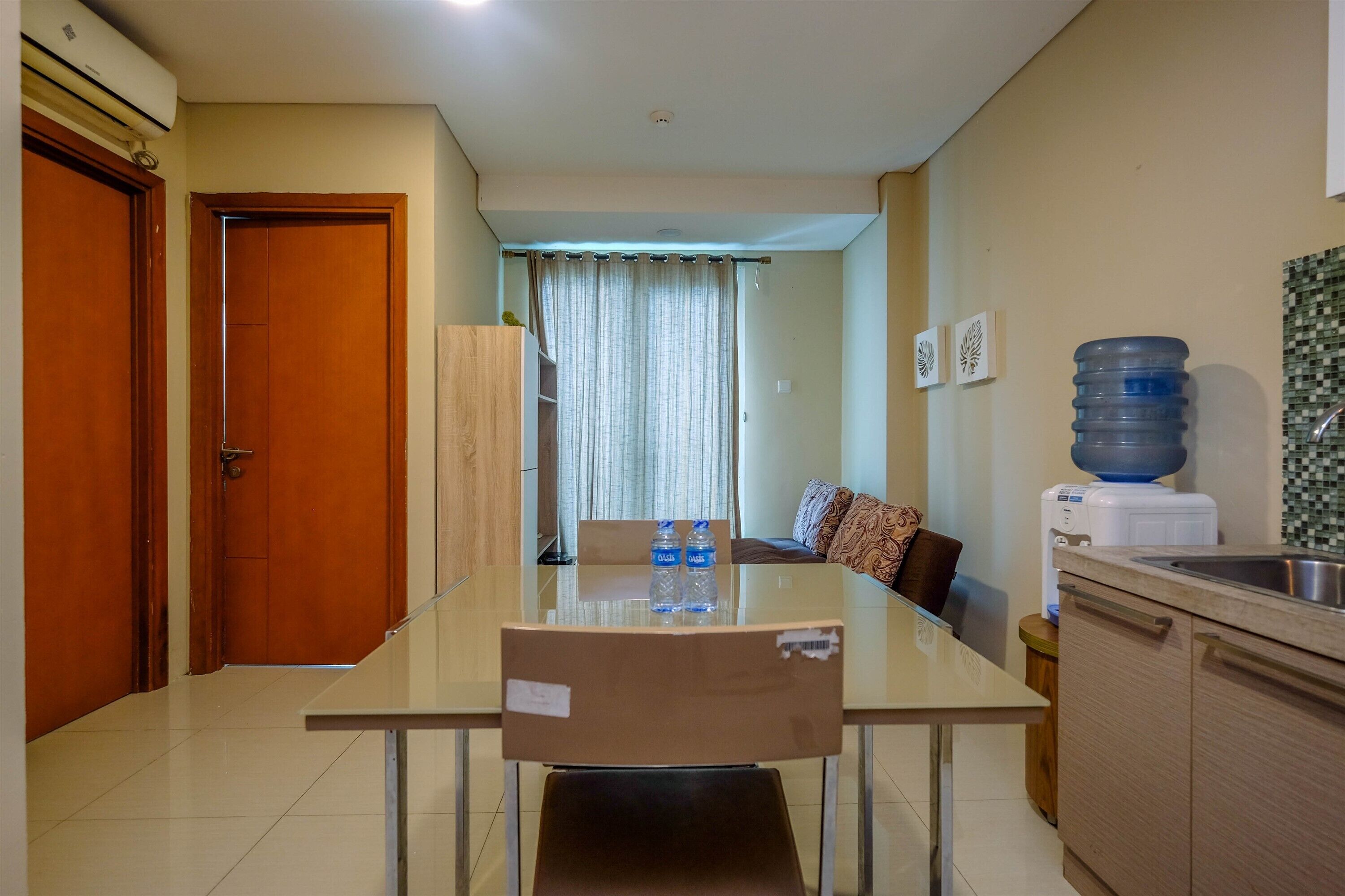 A modern kitchen with a dining area, a water dispenser, and a large water bottle.