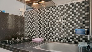 A kitchen with a checkered backsplash, stainless steel appliances, and a sink.