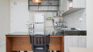 A modern kitchen with a central island, a built-in oven, and a hanging pendant light.