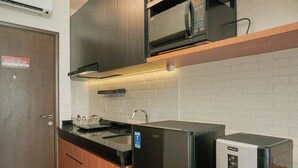 Una cocina compacta con microondas, refrigerador y pileta.