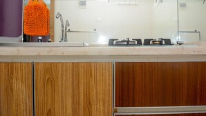 A bathroom with a wooden vanity, a sink, and a mirror. - Homey Studio Pakubuwono Terrace Apartment (Jakarta)