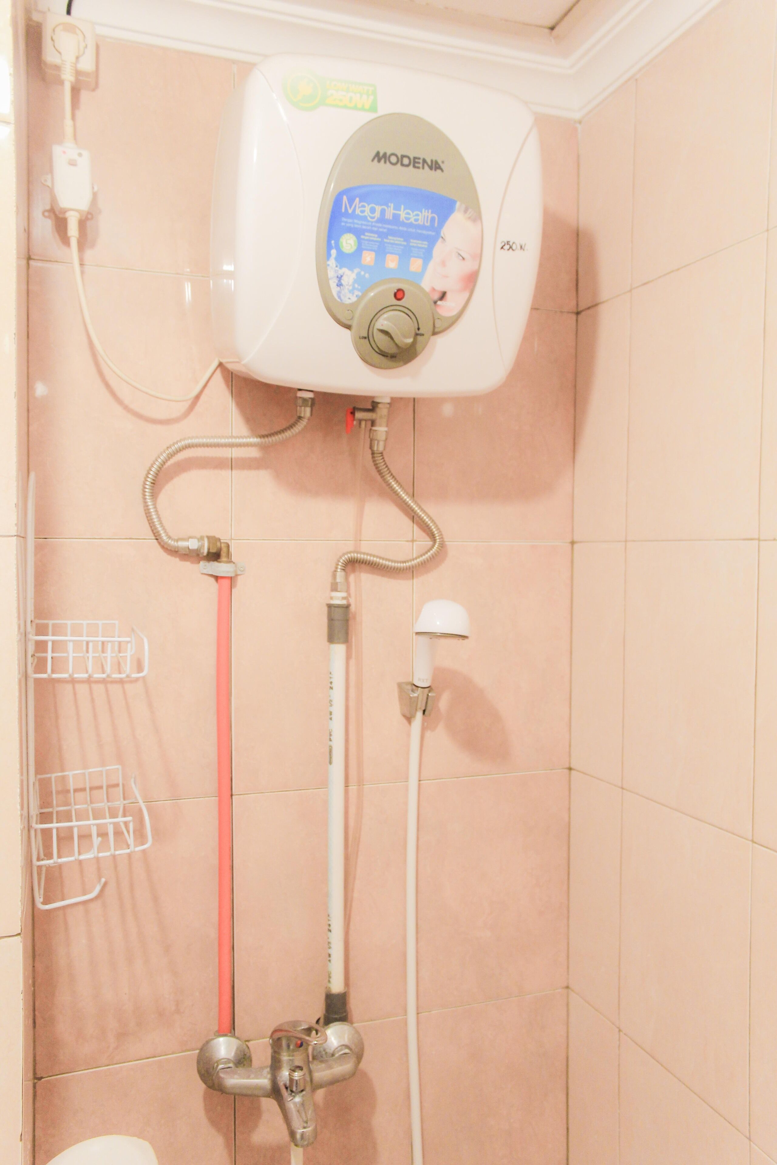Un baño con calentador de agua, cabezal de ducha y secador de manos.