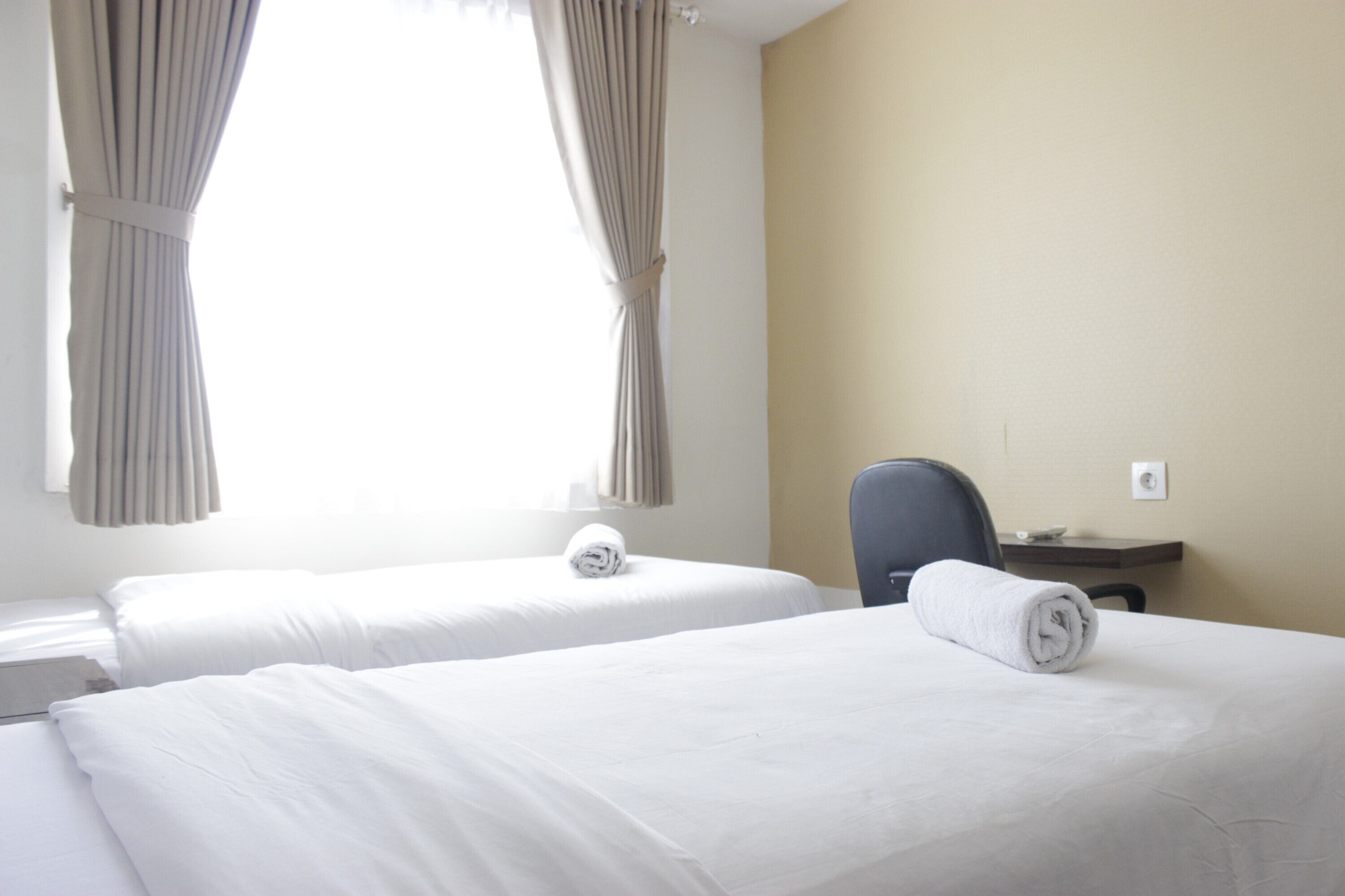 Una habitación de hotel con dos camas, un escritorio y una silla.