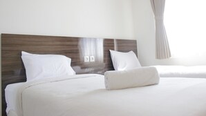 A hotel room with two beds, a wooden headboard, white bedding, and a window with curtains.