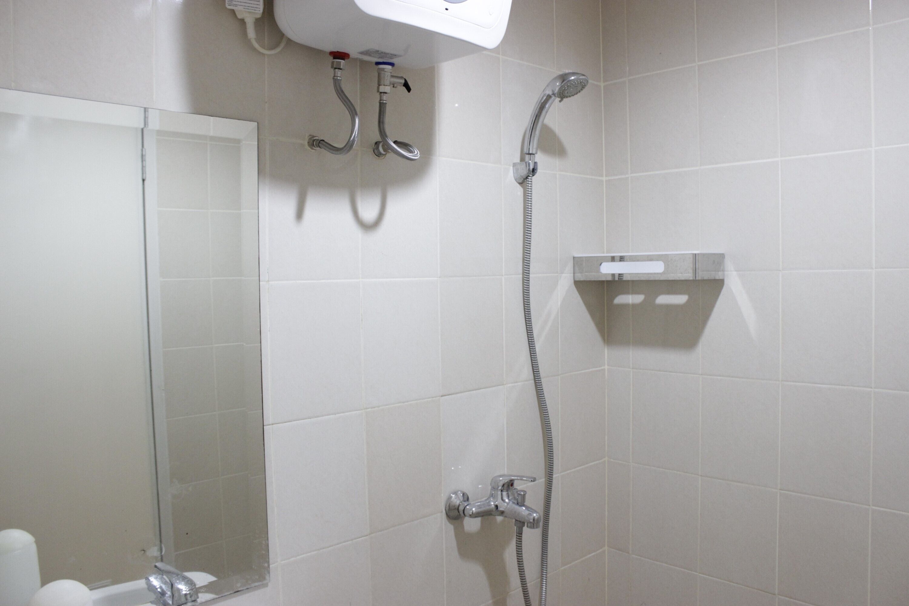 Une salle de bain avec une douche, des toilettes et un miroir.