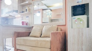 Eine moderne Küche mit einem beigen Sofa, einem Wasserspender und einem großen Spiegel über der Arbeitsfläche.
