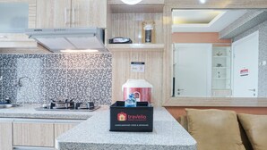 Eine moderne Küche mit einer Granit Arbeitsplatte, einer Box mit dem Markennamen travelio und einer Mikrowelle.
