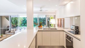 A modern kitchen with a large window, a built-in microwave, and a sink.