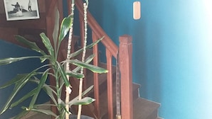 A staircase with a blue wall and a potted plant. - Maison à la Campagne 15min de la mer (Beaulieu-Sous-la-Roche)