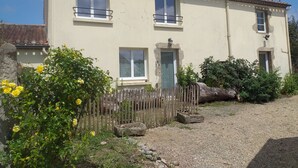 A two-story building with a beige facade, multiple windows, and a small porch area. - Maison à la Campagne 15min de la mer (Beaulieu-Sous-la-Roche)