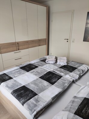 Ein Schlafzimmer mit einem Bett, einem Kleiderschrank und einer Tür.
