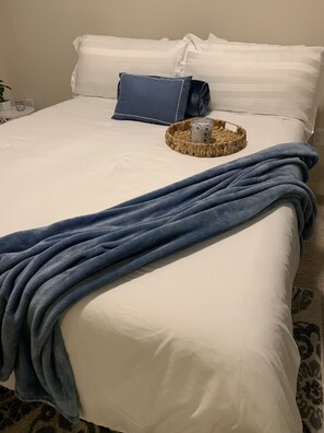 Restful retreat with a neatly made bed and a woven basket.