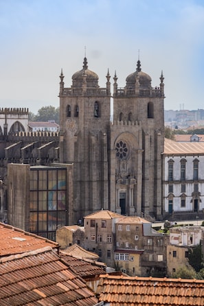 A historic cathedral with two prominent towers, a large rose window, and a clock. - Victorias Studios - Clérigos (Porto)