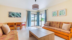 Un salon moderne comprenant un canapé, une table basse et un coin repas avec des chaises et une table.