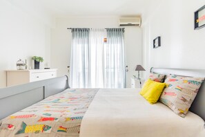 A neatly arranged bedroom with a bed, a bedside table, a lamp, and a window with curtains. - Quinta das Palmeiras Pool & Beach in Pêra (Lagoa)