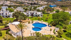 A resort with multiple villas, a large central pool, and a view of the surrounding landscape. - Happy House in Clube Albufeira (Albufeira)