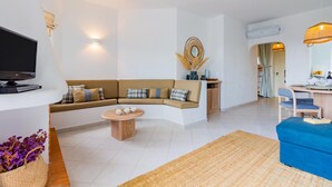 A modern living room with a beige sofa, a coffee table, and a television. - Clube Albufeira, Family Holidays with Pool View (Albufeira)