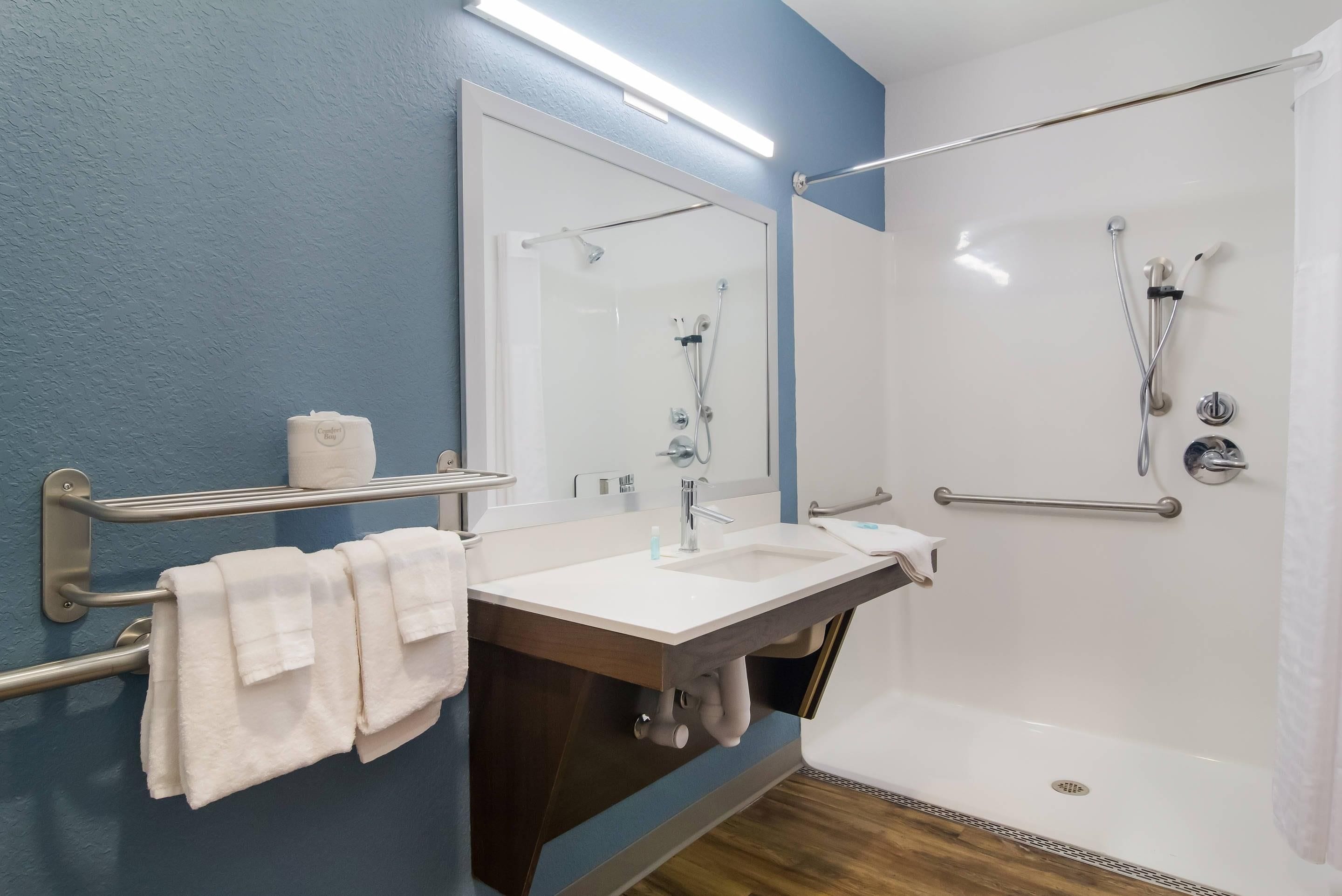 Un baño moderno con una bañera, un lavabo, un espejo y un perchero para toallas.
