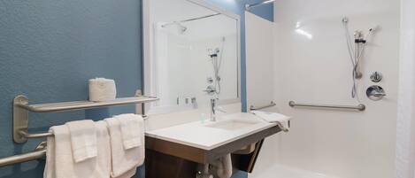 Un baño moderno con una bañera, un lavabo, un espejo y un perchero para toallas.
