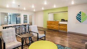 Un interior moderno con zona de comedor, mostrador de recepción y un amplio ventanal.