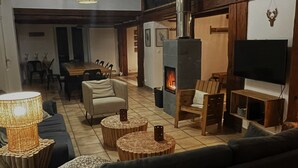 A cozy living room with a fireplace, sofas, and wooden decor.