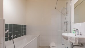 Ein modernes Badezimmer mit Badewanne, Dusche und Waschbecken.
