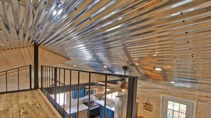 Une cuisine moderne dotée d’appareils électroménagers en acier inoxydable, d’un plancher en bois et offrant une vue sur l’étage supérieur.