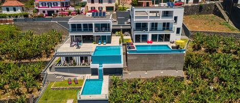 Un complexe résidentiel moderne comprenant plusieurs bâtiments, une piscine et un jardin bien entretenu.